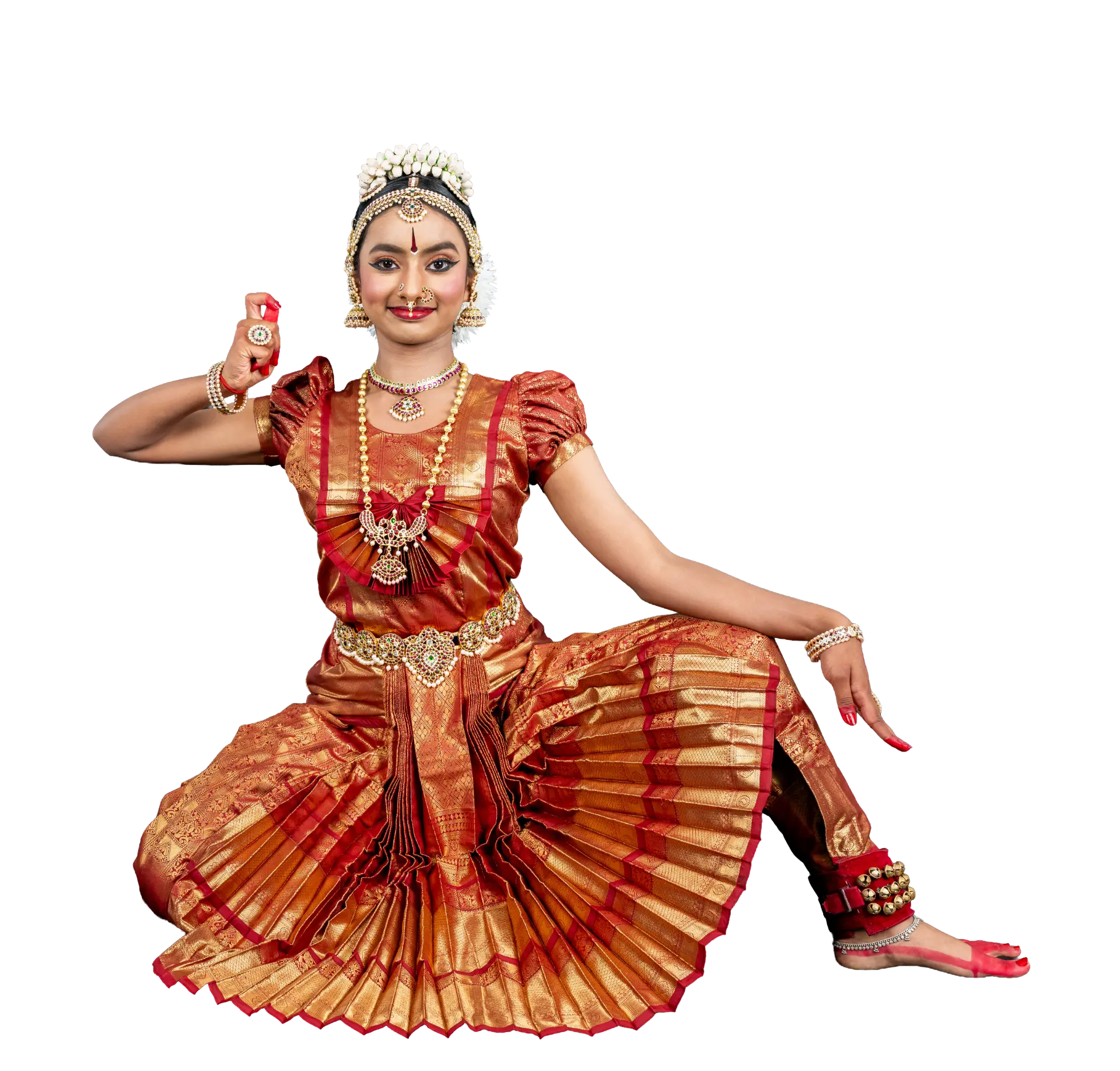 Surabhi seated in a Bharatanatyam pose in red and gold